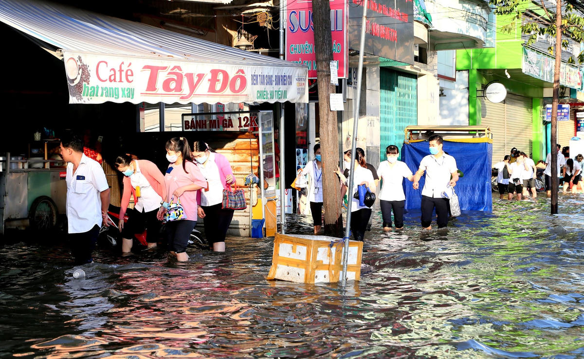 Công nhân và người dân đi lại khó khăn vì nhiều tuyến đường ngập sâu.