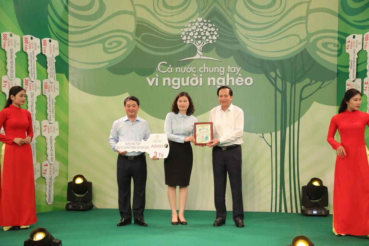 Phó Chủ tịch- Tổng Thư ký Hầu A Lềnh và Bộ trưởng Bộ LĐ-TB&XH Đào Ngọc Dung tiếp nhận ủng hộ từ Ngân hàng TMCP Đầu tư và Phát triển Việt Nam (BIDV).