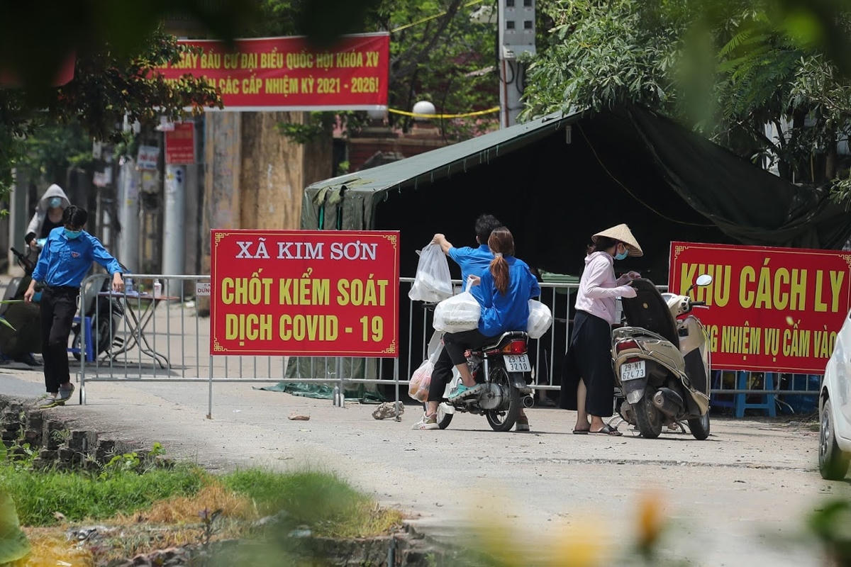 Tiếp tế cho người dân trong khu vực cách ly ở xã Kim Sơn. Ảnh: Quang Vinh.