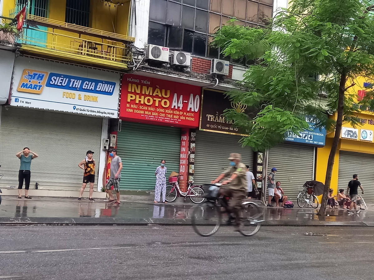 Dọc phố Quốc Tử Giám nhiều người dân sau khi tập thể dục đã tụ tập ngồi nói chuyện không đảm bảo khoảng cách an toàn.