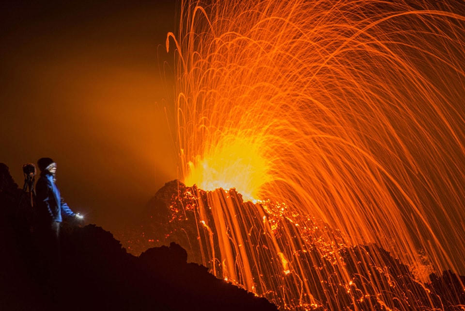 ​16. Một người đứng nhìn ngọn núi lửa Piton de la Fournaise trong vụ phun trào vào ngày 05 tháng 02 năm 2015, tại đảo French Indian Ocean thuộc Réunion Island. Đây là đợt phun trào thứ hai trong năm qua tại Piton de la Fournaise sau 3 năm im lặng. Ảnh Fabrice Wislez / AP.