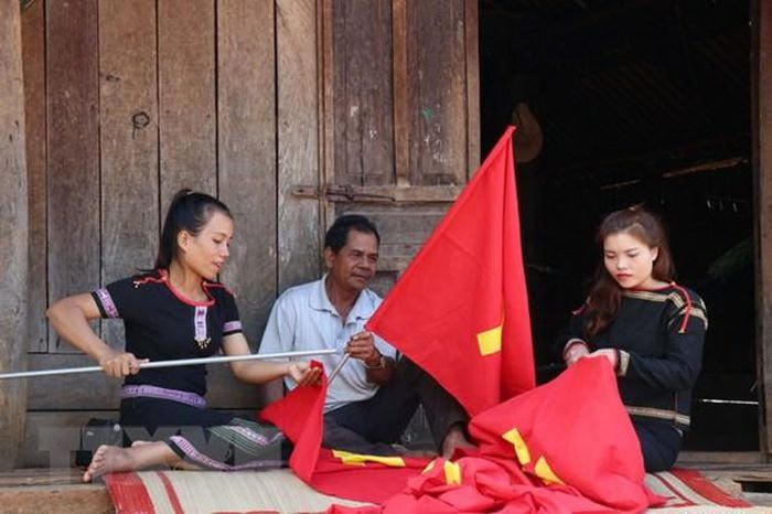 Người dân may cờ chào mừng Đại hội lần thứ XIII của Đảng.