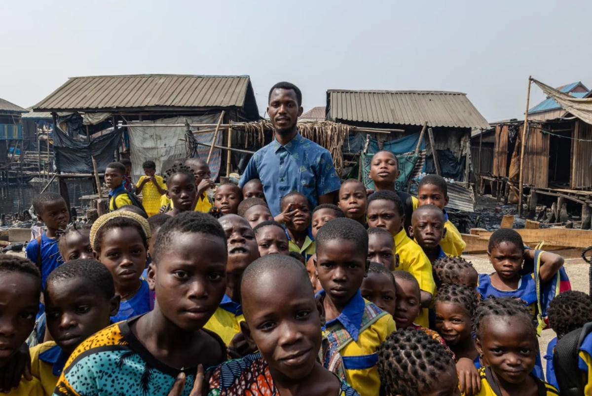 Thầy Emmanuel Abiodun Oke, 31 tuổi, hiệu trưởng trường Whanyinna, cùng các học sinh của mình. Ảnh: The Guardian.