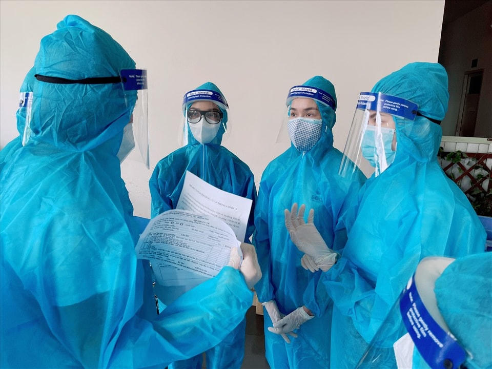 Các người đẹp trong trang phục bảo hộ kín mít tham gia công tác điều phối hỗ trợ người dân tiêm vaccine.