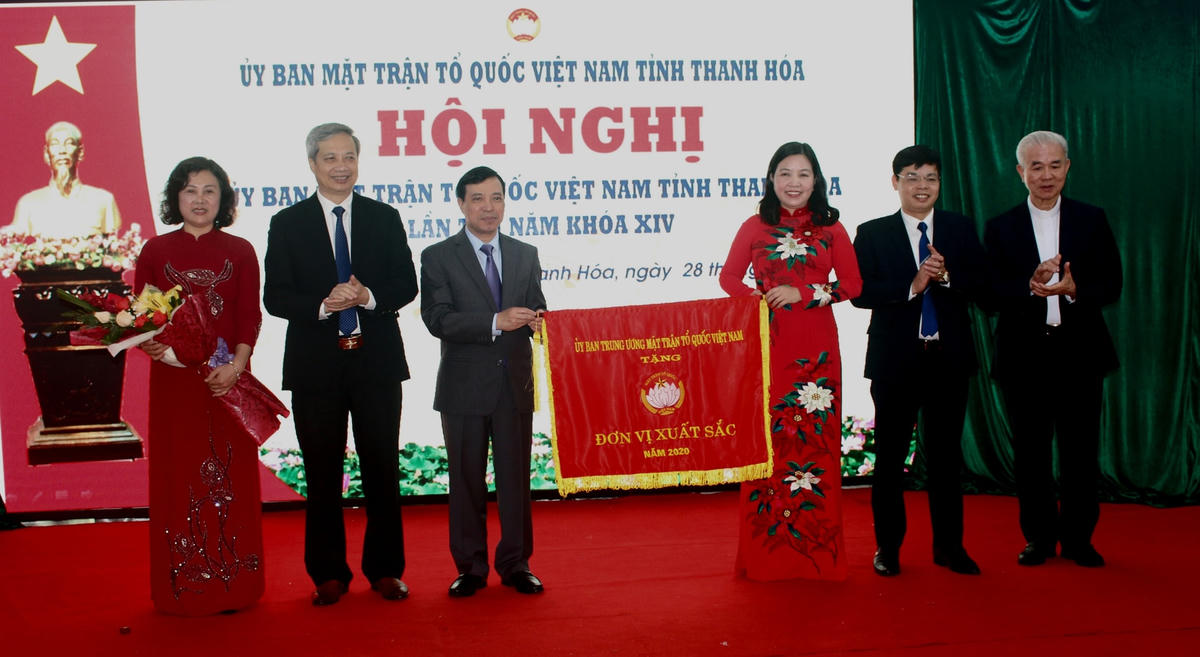 : Ông Lại Thế Nguyên, Phó Bí thư Thường trực Tỉnh ủy Thanh Hóa và Linh mục Trần Xuân Mạnh, Phó Chủ tịch không chuyên trách UBTƯ MTTQ Việt Nam tặng Cờ xuất sắc của UBTƯ MTTQ Việt Nam cho Ủy ban MTTQ Việt Nam tỉnh Thanh Hóa.