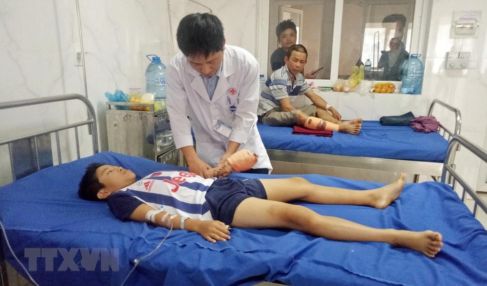 Bác sĩ kiểm tra vết thương và theo dõi cử động bàn tay trái của bệnh nhân. (Ảnh: TTXVN phát).