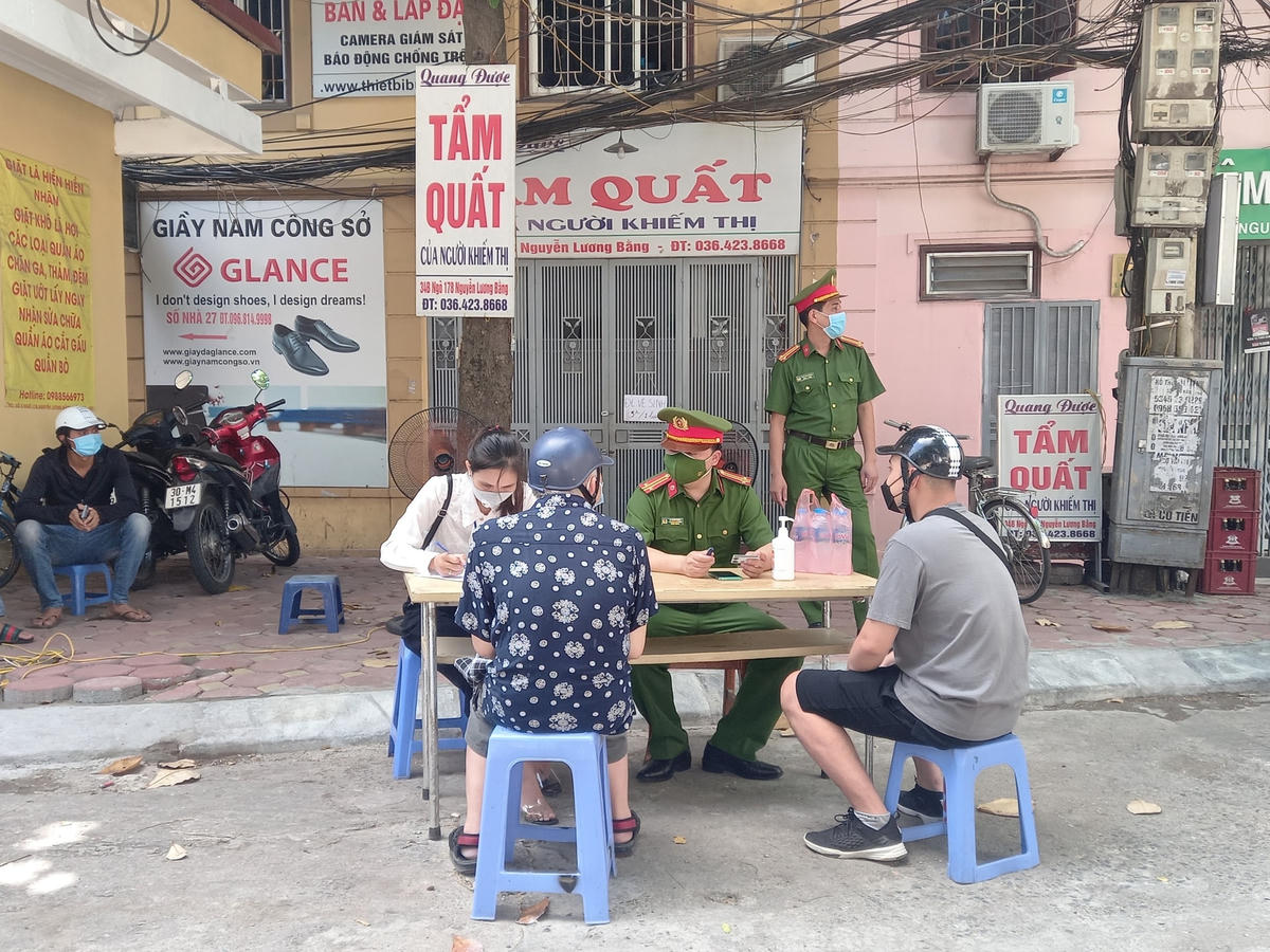 Lực lượng chức năng yêu cầu người dân khai báo thông tin tại chốt kiểm soát khu vực vườn hoa 1/6 (phường Quang Trung, quận Đống Đa).