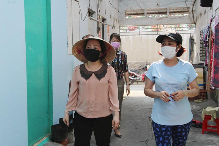 Chị Thùy Dương (áo xanh) thăm hỏi và giảm tiền thuê trọ cho lao động nghèo.