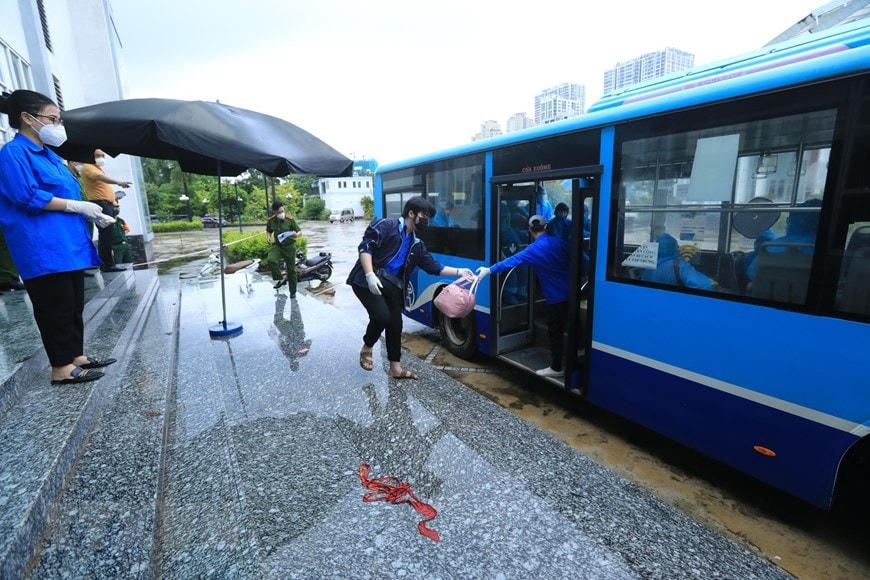 Lực lượng tình nguyện viên hỗ trợ giúp người dân vận chuyển đồ đạc vào khu chờ người nhà đến đón. (Ảnh: Tuấn Anh/TTXVN)