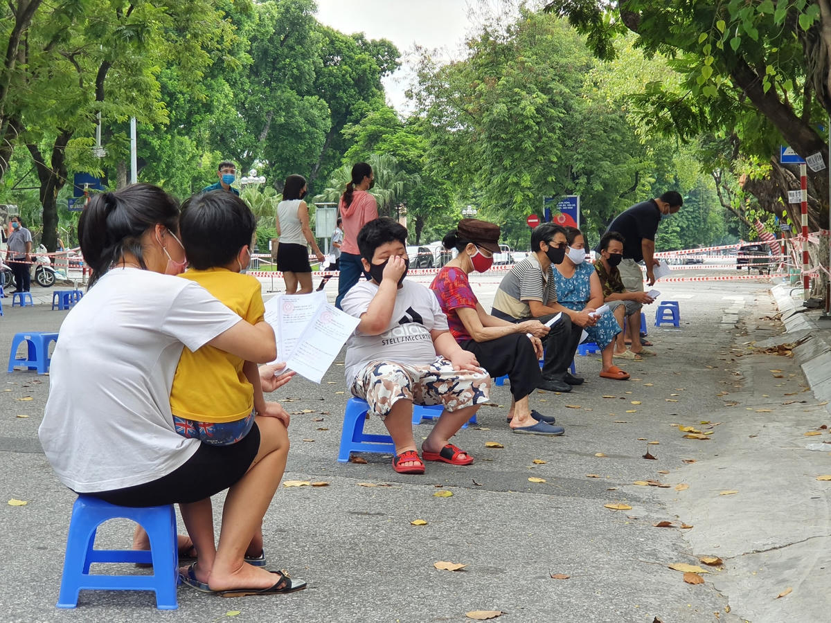 Sau khi điền phiếu, người dân sẽ được hướng dẫn ngồi chờ đúng theo giãn cách.