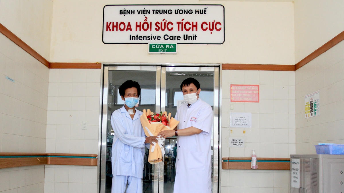 GS.TS Phạm Như Hiệp, Giám đốc Bệnh viện Trung ương Huế tặng hoa chúc mừng bệnh nhân H. được ra viện.