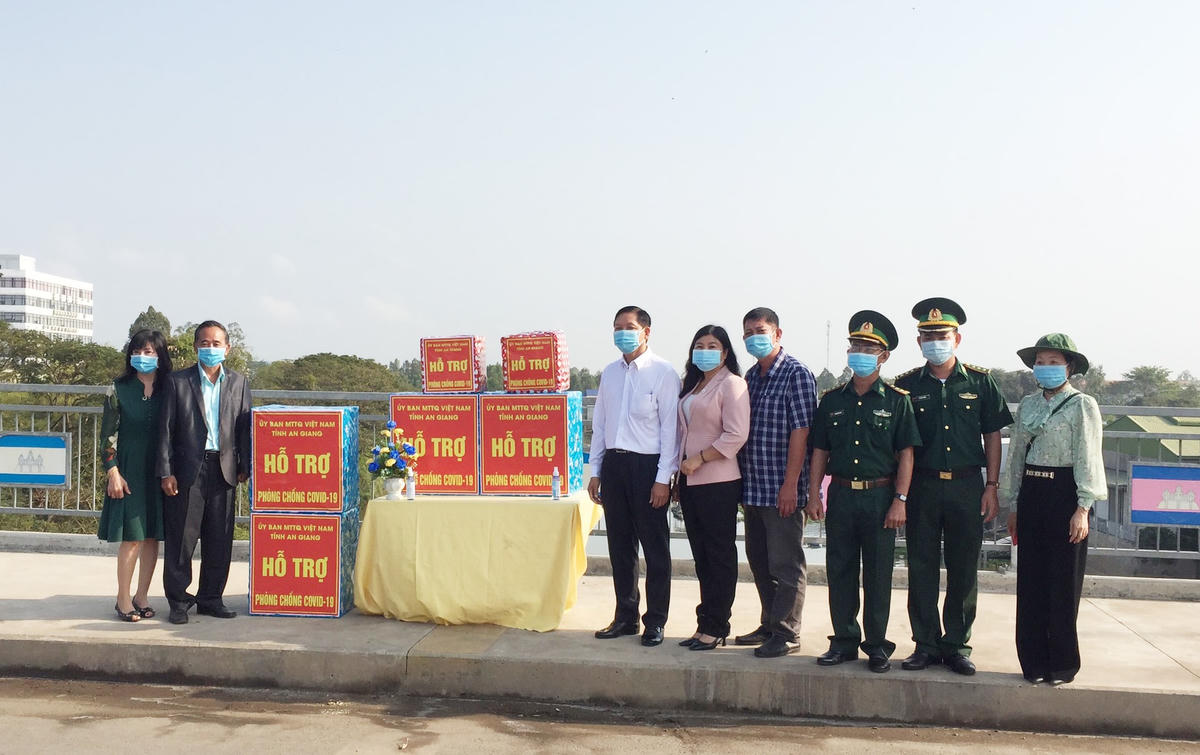 Mặt trận cùng lực lượng chức năng trao khẩu trang và nước sát khuẩn cho bà con người Việt ở Campuchia.