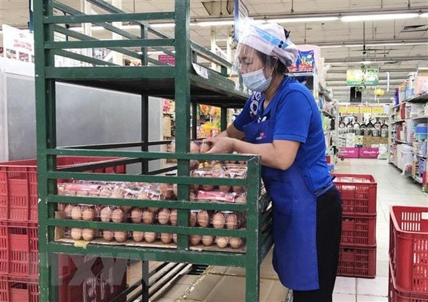 Nhân viên siêu thị Co.opmart bổ sung mặt hàng trứng gia cầm lên quầy/kệ. Ảnh: Mỹ Phương/TTXVN.  