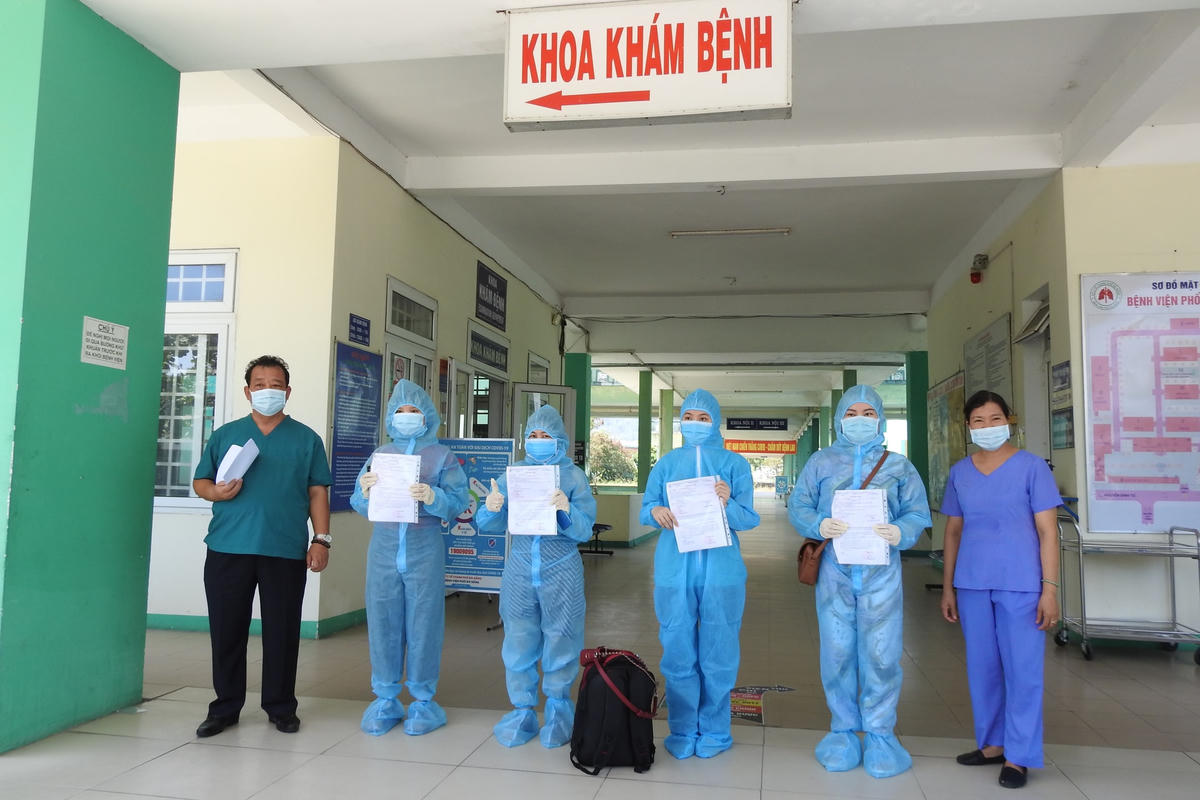 Bác sỹ Lê Thành Phúc, Giám đốc Bệnh viện phổi Đà Nẵng (trái) trao giấy ra viện cho 4 BN Covid-19 sáng 1/6. Ảnh B.Nguyên.