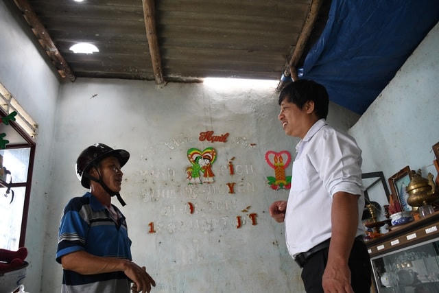Ông Nguyễn Văn Thủy (áo kẻ) được thầy Vũ (áo trắng) làm "cầu nối" hỗ trợ tôn, xà gồ sửa lại mái nhà hư hỏng trong bão số 9.  