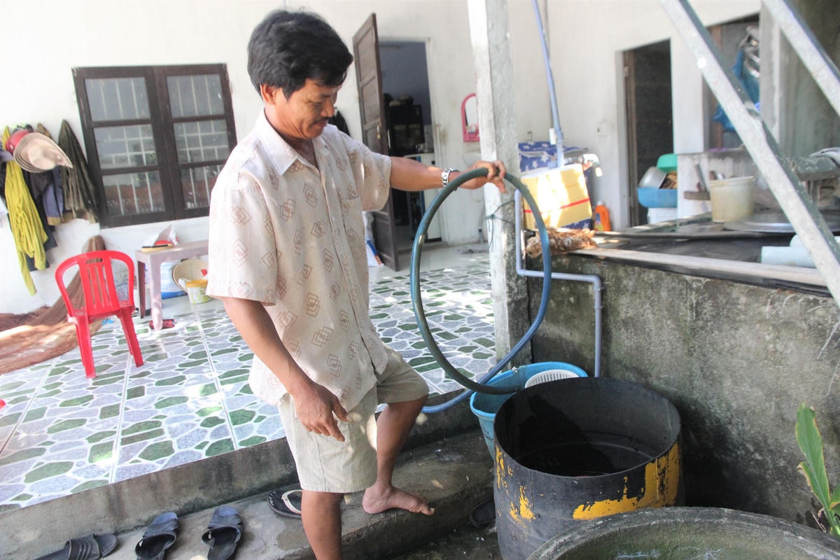 Ông Phạm Chức chỉ các ống nhựa bị phèn bám vàng đục.