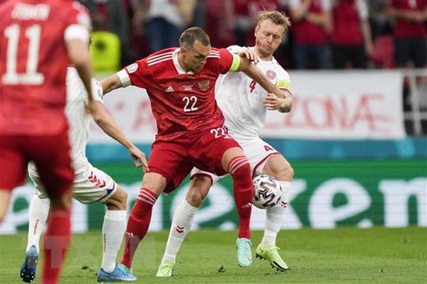 Hậu vệ Đan Mạch Simon Kjaer (phải) cản phá tiền đạo Nga Artem Dzyuba. (Ảnh: AFP/TTXVN).