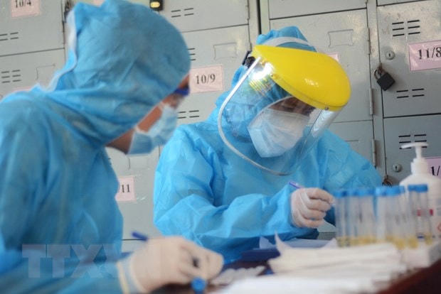 Các nhân viên y tế làm xét nghiệm SARS-CoV-2. (Ảnh: Văn Dũng/TTXVN).