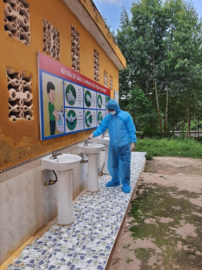 Hàng sáng, thầy Thành mặc đồ bảo hộ, đi kiểm tra đường điện, nước, các thiết bị quanh trường để chắc chắn cơ sở vật chất đảm bảo cho các em cách ly. Ảnh: NVCC.