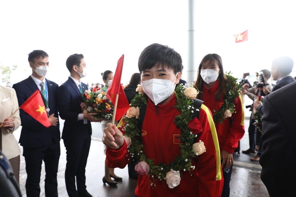 Các nữ tuyển thủ tiến vào sảnh VIP A của sân bay quốc tế trong sự chào đón nồng nhiệt của đại diện Liên đoàn Bóng đá Việt Nam (VFF) và người hâm mộ. (Ảnh: TTXVN).
