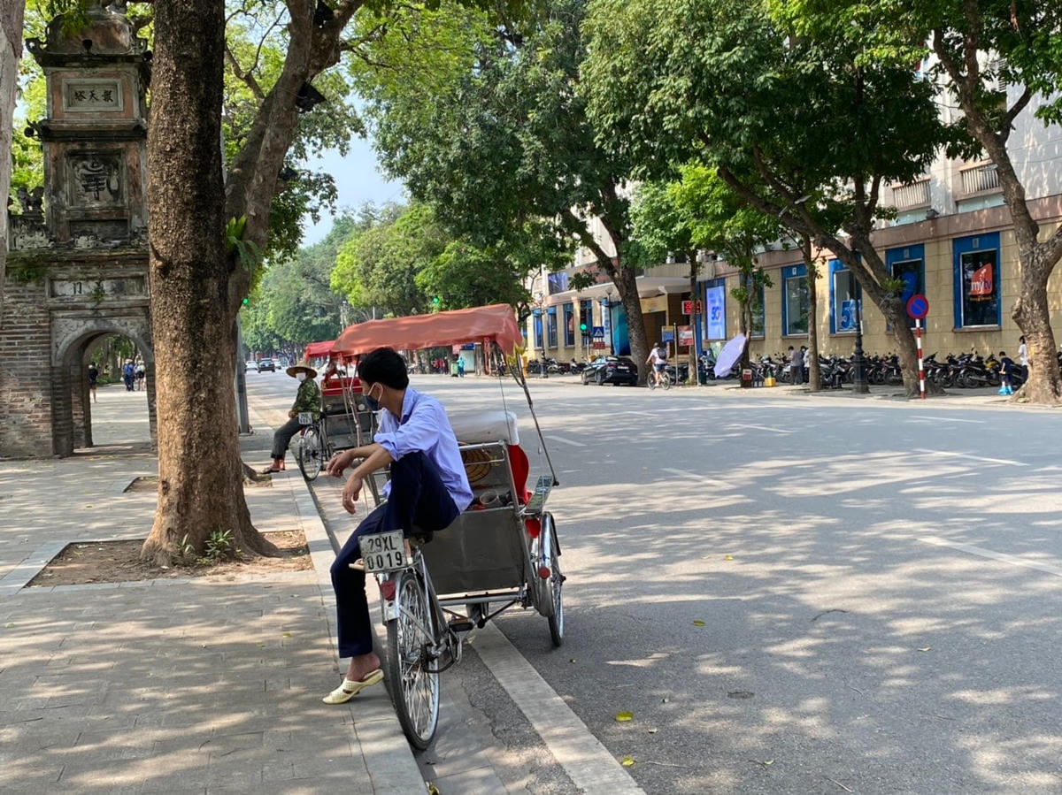 Những người đạp xích lô ngồi chờ khách quanh hồ Hoàn Kiếm. Ảnh: L.A..