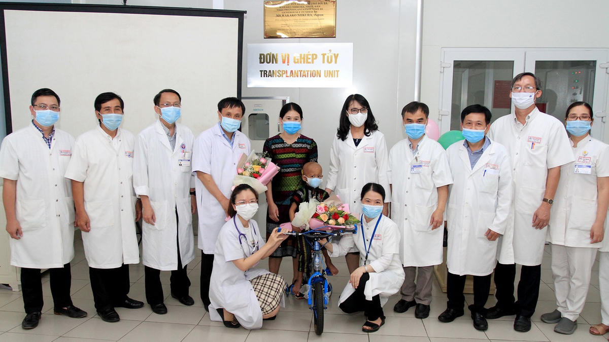 Lãnh đạo Bệnh viện Trung ương Huế tặng hoa chúc mừng bệnh nhi Hồ Chi Na ra viện. Ảnh: Bệnh viện cung cấp.