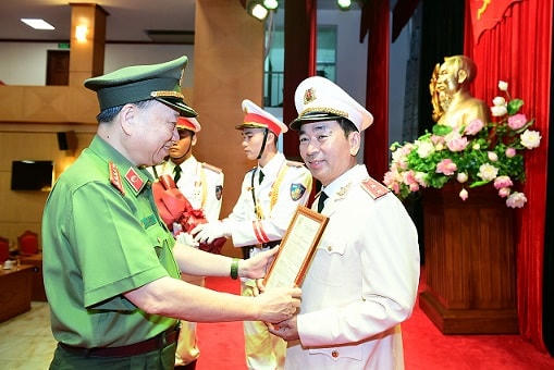 Bộ trưởng Tô Lâm trao Quyết định của Chủ tịch nước thăng cấp bậc hàm từ Thiếu tướng lên Trung tướng đối với Thứ trưởng Trần Quốc Tỏ.