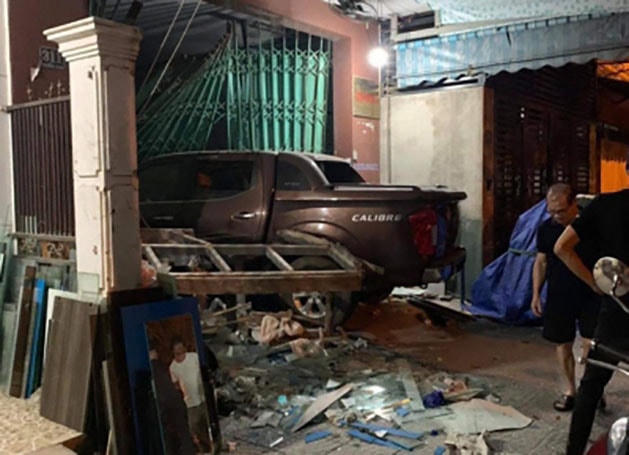 Chiếc ô tô tông sập phần mái hiên và cánh cửa sắt của nhà dân.  