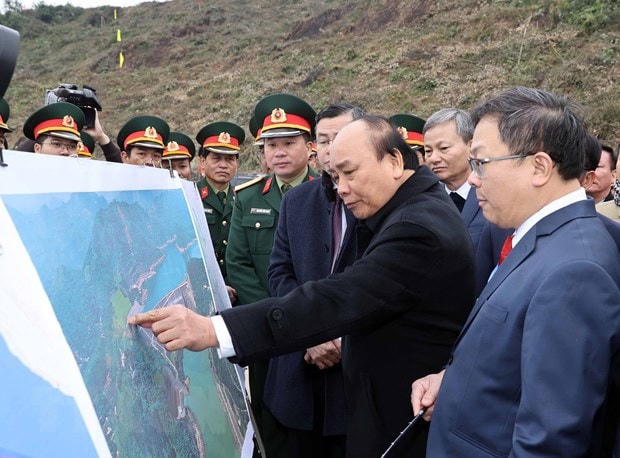 Thủ tướng Nguyễn Xuân Phúc xem hình ảnh về địa điểm thực hiện Dự án Nhà máy thủy điện Hòa Bình mở rộng. (Ảnh: Thống Nhất/TTXVN).