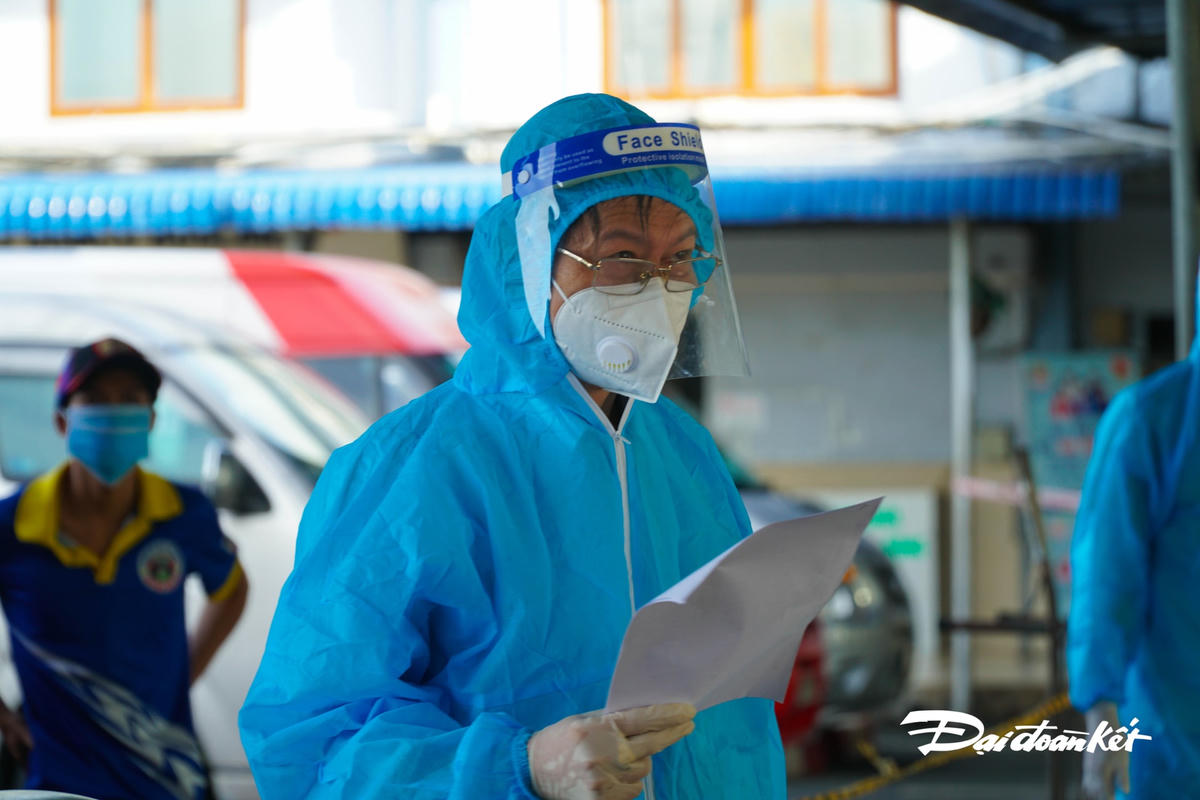 Lực lượng y tế đọc tên lượt người vào khai báo y tế, điền thông tin test Covid-19.
