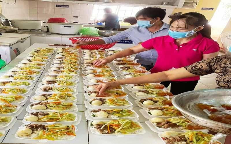 Các thầy cô giáo tại bếp ăn trường mầm non 24/3 đang thực hiện việc chia cơm cho khu cách ly Trung tâm y tế huyện Sơn Hòa.