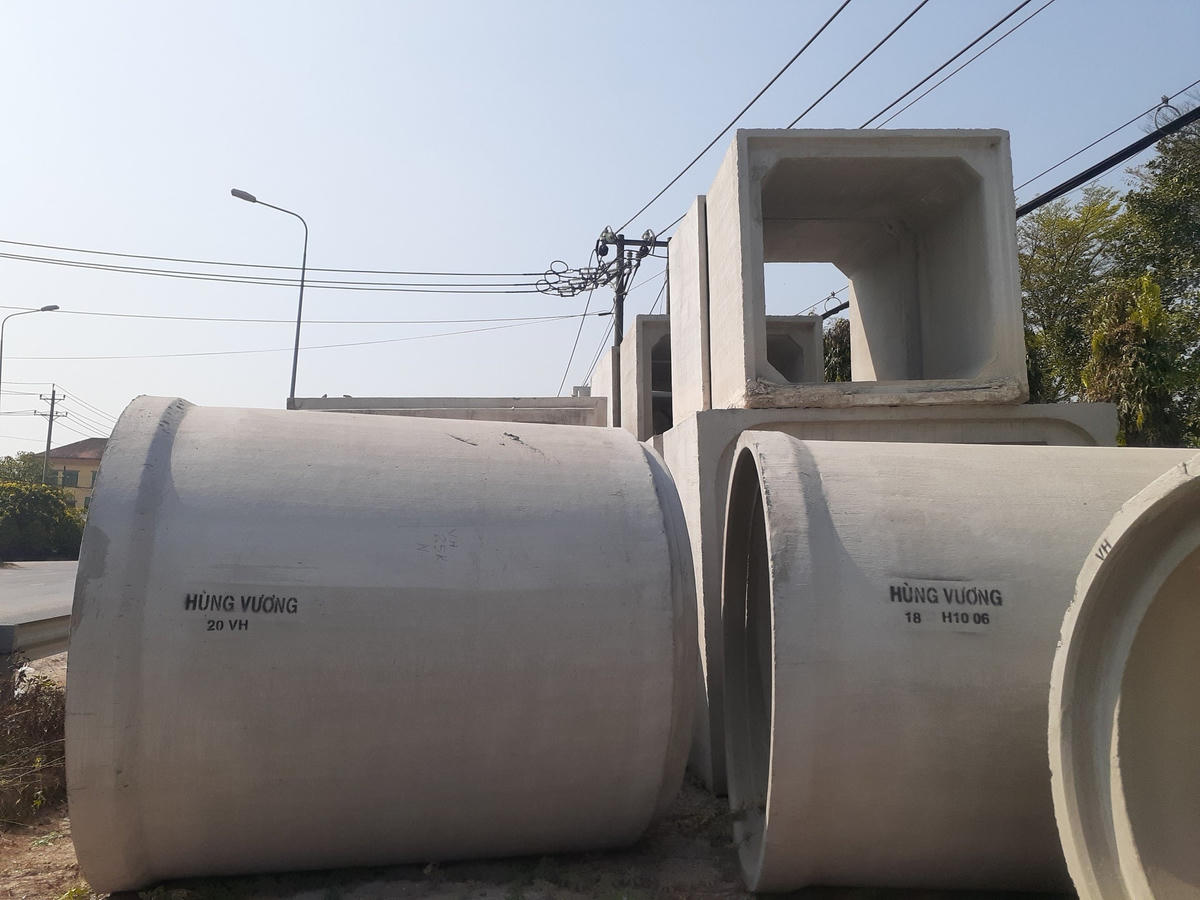 Nhiều ống cống với đường kính lớn, xếp chồng lên nhau sát ngay đường lưới điện.