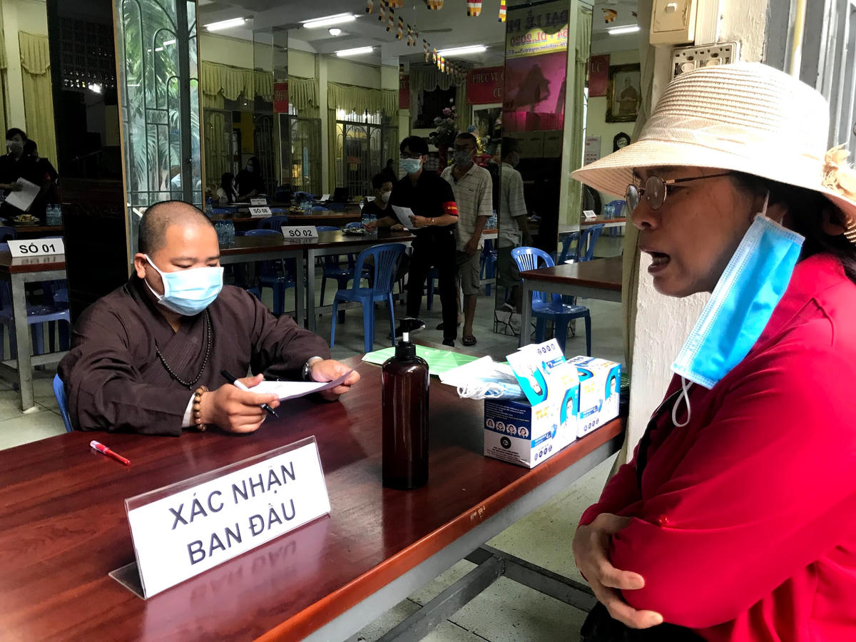 Nhà chùa có bàn ghi danh, đăng ký theo số thứ tự cho người dân.