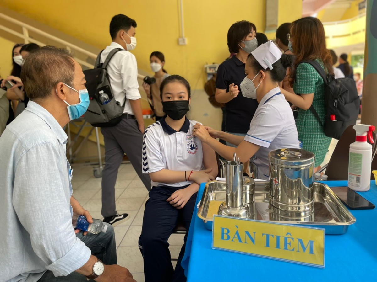 Học sinh được nhân viên y tế tiêm vaccine sau khi khám sàng lọc.