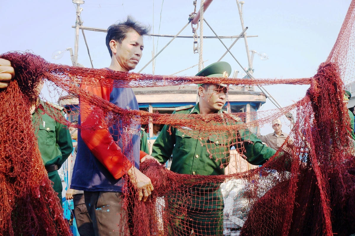Ngư dân Võ Quang Thái bên con tàu bị tàu lạ tấn công hư hỏng.