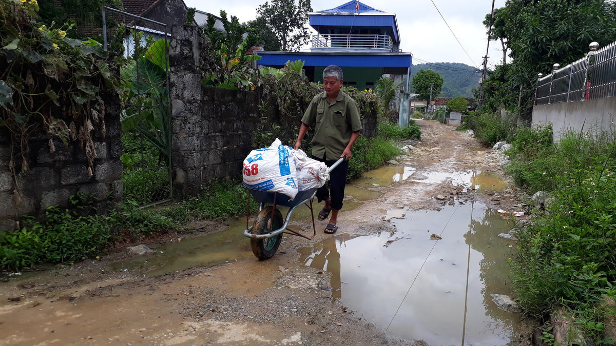 Ông Bùi Văn Cận, ở thôn Hạ Trung Ninh, xã Liêm Sơn phải đẩy thóc ra đường lớn để sát gạo.