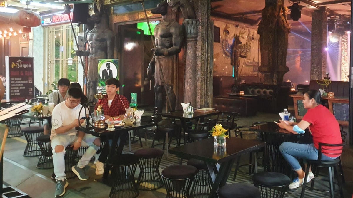 Bên ngoài một quán bar, lác đác có vài vị khách.