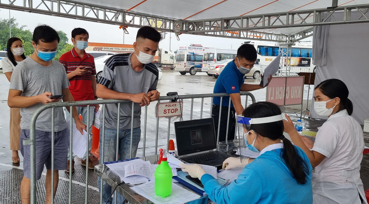Người dân xếp hàng đợi nộp bản khai y tế tại chốt Pháp Vân - Cầu Giẽ sáng nay (27/9). Ảnh: Nam Anh.
