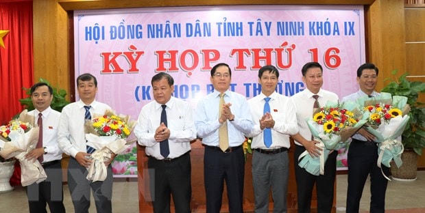 Bí thư Tỉnh ủy Tây Ninh Phạm Viết Thanh và Chủ tịch UBND tỉnh Phạm Văn Tân tặng hoa chúc mừng các cán bộ được bầu vào các chức danh Phó Chủ tịch HĐND, UBND và ủy viên UBND tỉnh nhiệm kỳ 2016-2021. (Ảnh: Lê Đức Hoảnh/TTXVN).