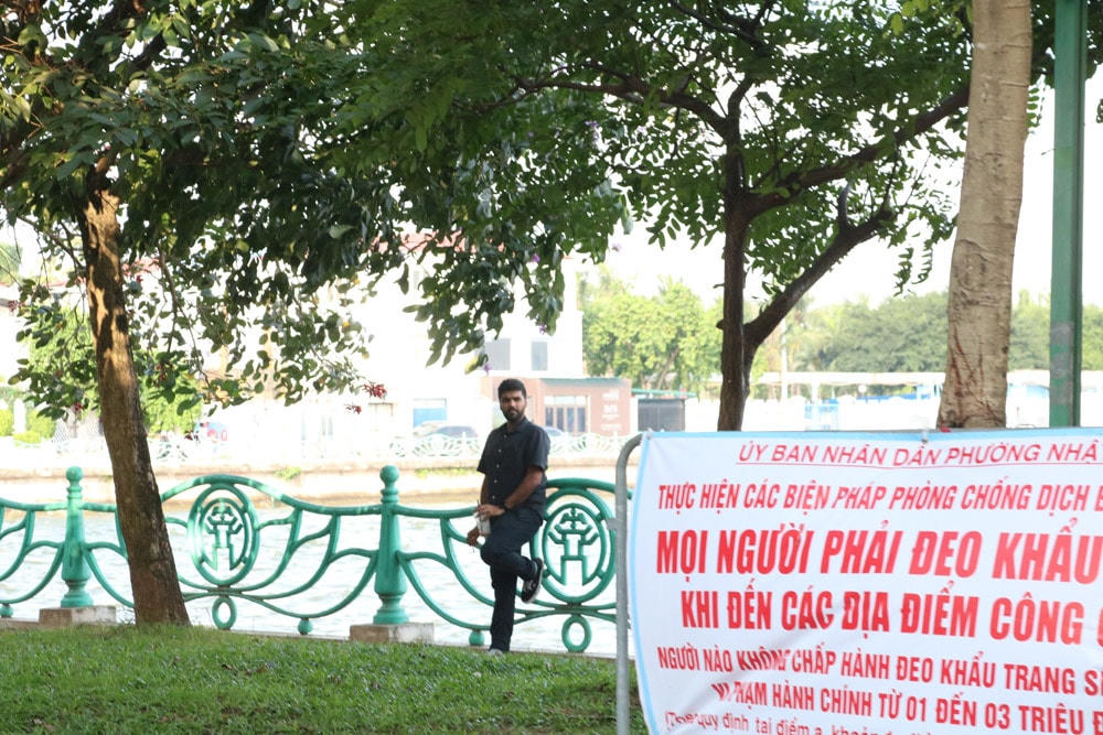 Mặc dù có biển yêu cầu mọi người phải đeo khẩu trang khi đến nơi công cộng ở ngay gần đó nhưng người đàn ông nước ngoài này vẫn phớt lờ.