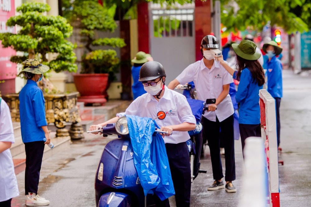 Học sinh được kiểm tra thân nhiệt trước khi vào lớp học.