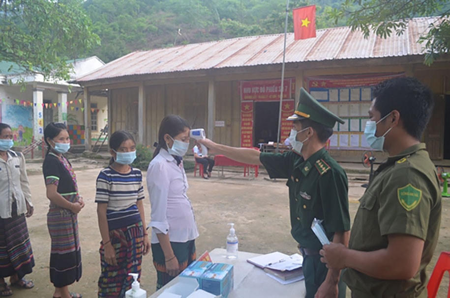 Cán bộ Đồn Biên phòng Mỹ Lý kiểm tra thân nhiệt cho cử tri đến tham gia bầu cử. Ảnh: Báo QĐND.  