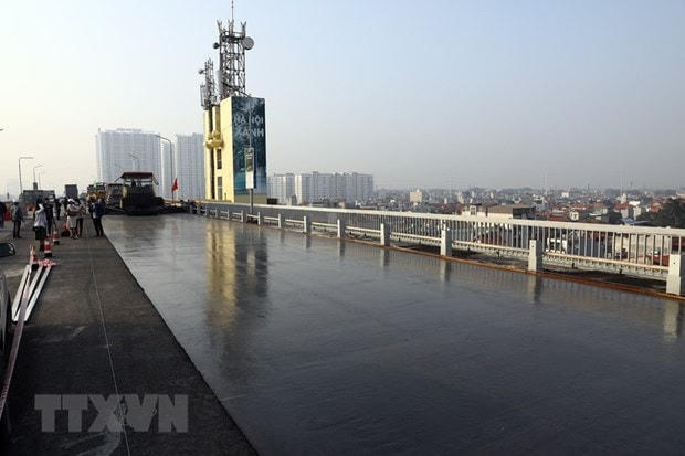 Thi công thảm bê tông Polymer trên mặt cầu Thăng Long. Ảnh: Huy Hùng/TTXVN.  