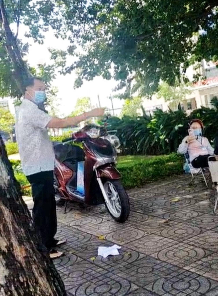 Ông C. xé biên bản do Tổ công tác lập xử phạt bà T. và nhờ nhắn lại Chủ tịch phường đừng gọi ông xin quà hỗ trợ hộ nghèo. (Ảnh: Cắt từ clip).