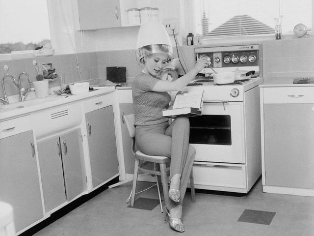Bức ảnh chụp hồi năm 1963 ghi lại hình ảnh nữ diễn viên người Anh Barbara Roscoe khi vừa nấu nướng, vừa sấy tóc tại nhà.  