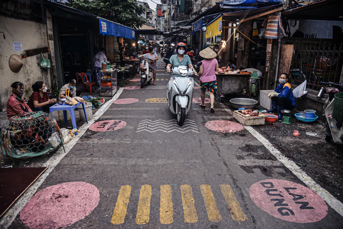 Trước mỗi quầy bán hàng ở chợ đều được vẽ các ô hình tròn màu hồng dành cho người dân tới để mua hàng.