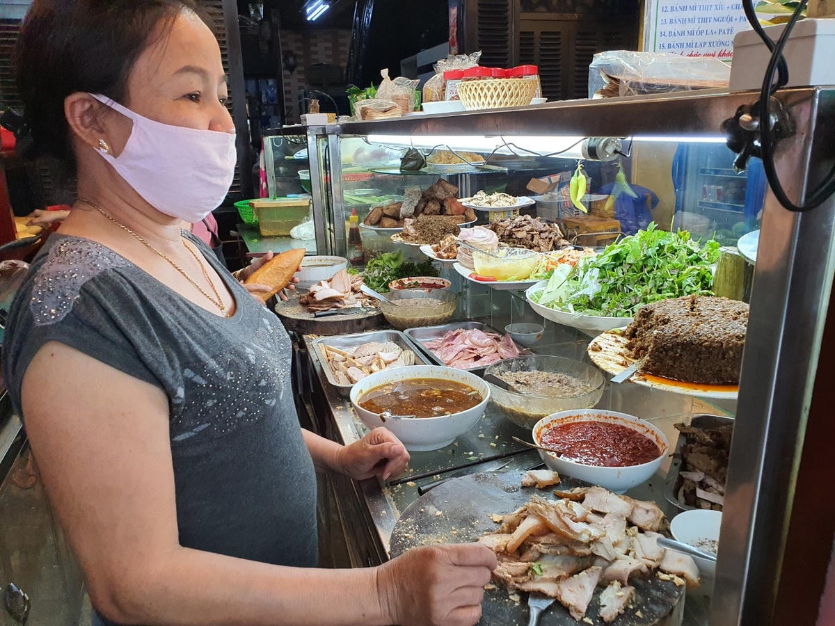 Nhân viên bên trong quầy bán bánh mì của mình.