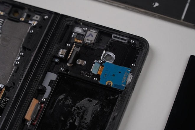 Bên cạnh bản lề của Galaxy Z Fold3 có 4 sợi cáp để liên kết màn hình với phần bo mạch của máy. Cách thiết kế này của Samsung giúp hạn chế hiện tượng căng cáp, đứt cáp khi gập thường xuyên.