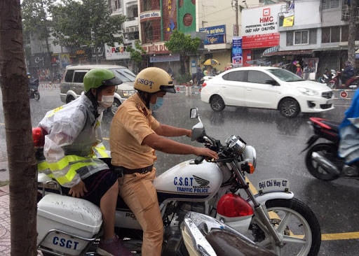 Đại uý Nguyễn Anh Tú nhường áo mưa, chở nữ sinh đến điểm thi, ngày 9/8.
