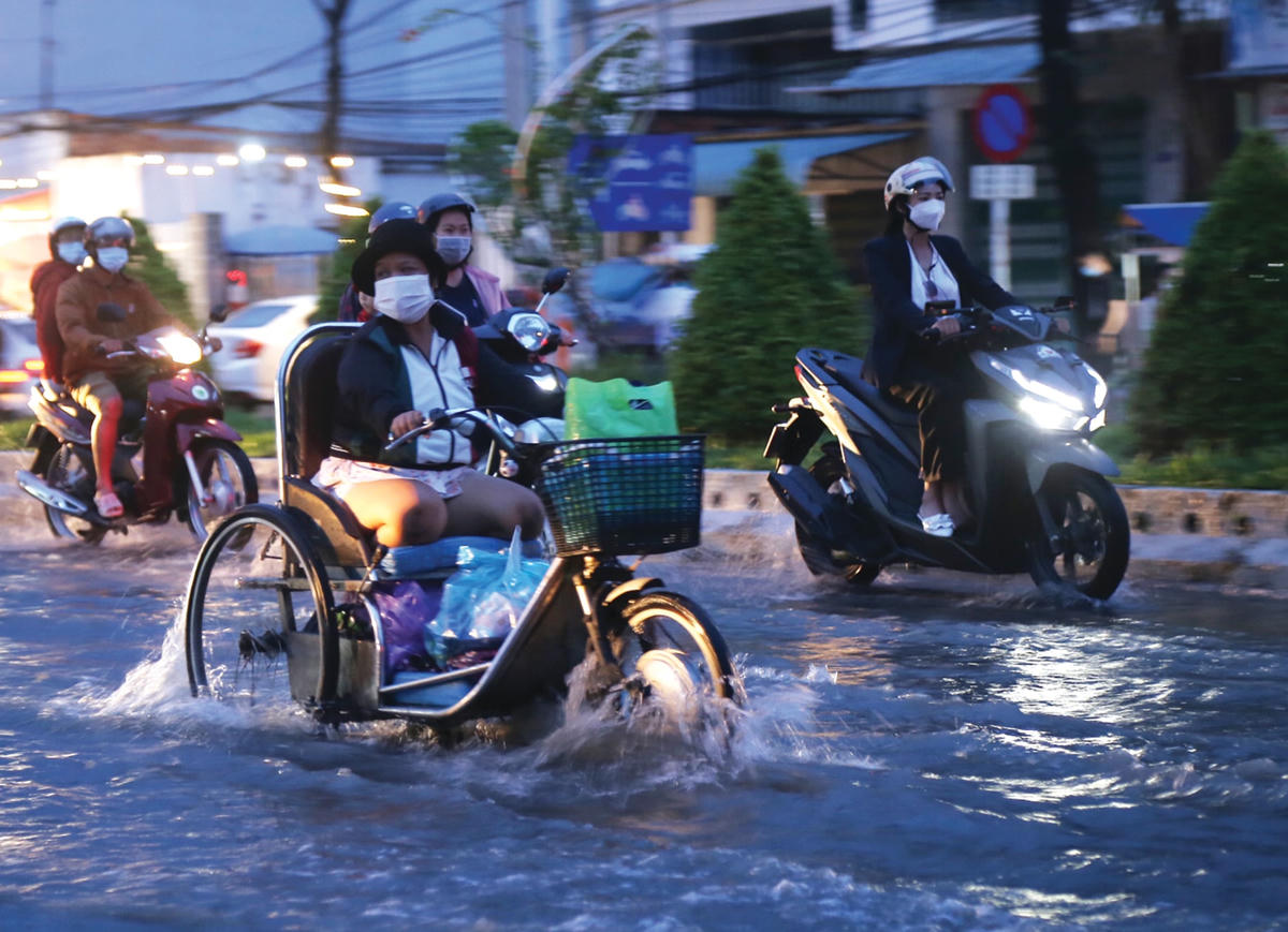 Triều cường dâng cao khiến người dân đi lại khó khăn.